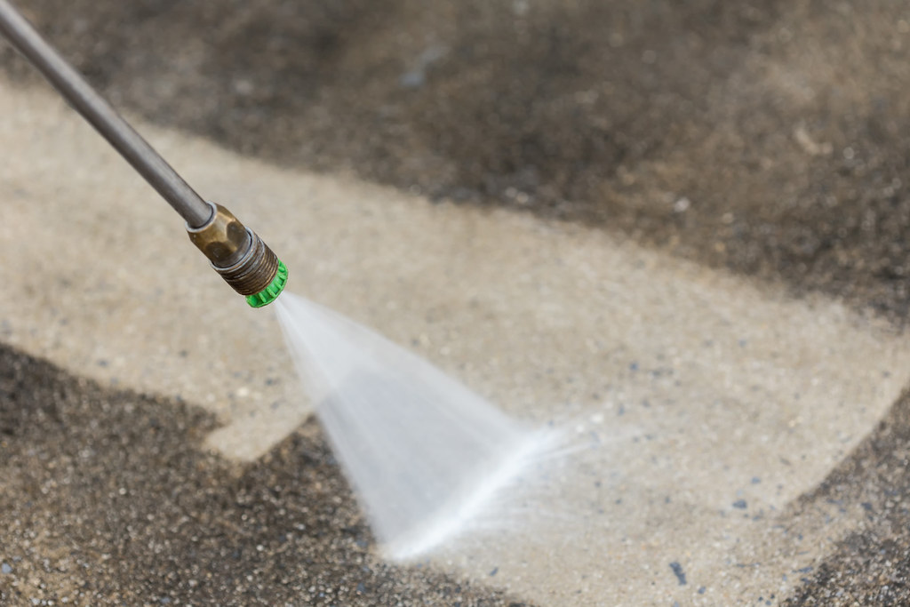 Professional pressure washing in Vancouver cleaning concrete driveway with high-pressure water